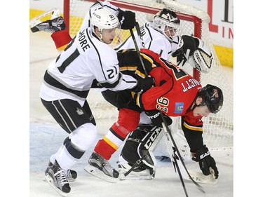 Sam Bennett of the Calgary Flames is up[ending by Los Angeles Kings defenceman Nick Shore in front of goalie Jhonas Enroth during the second period at the Saddledome Tuesday April 5, 2016.