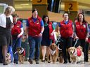A group of dog owner volunteers and their four-legged friends walk the aisle at Calgary Airport for the launch of new Pre-Board Pals program at Calgary Airport Monday April 11, 2016. The program is a collaboration between the Calgary Airport Authority and Pet Access League Society, brings therapy dogs to the airport to reduce passenger stress by encouraging one-on-one interactions with the animals.