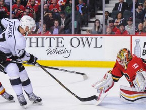 John Carter of the Los Angeles Kings scores the game-winner in overtime against Calgary Flames goaltender Joni Ortio during NHL action in Calgary on Tuesday. Kings were 5-4 winners.