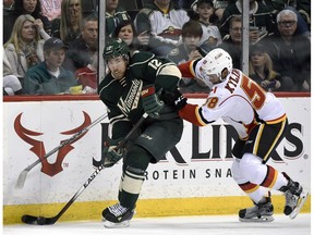 Minnesota Wild's David Jones (12) handles the puck against Calgary Flames' Oliver Kylington (58) during the second period of an NHL hockey game Saturday, April 9, 2016, in St. Paul, Minn.