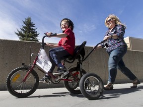 Jeremiah Botbijl, 6, rides a customized bicycle while being followed by Sheralee Stelter, executive director of Cerebral Palsy Kids and Families, on Saturday.