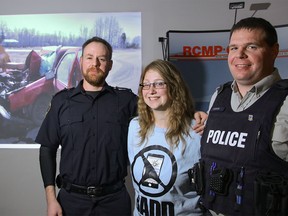 Melody Battle with Rocky Mountain House paramedic Jarrett Chisholm, left, who pulled her from the wreckage of her car after a collision with a road grader that occurred when she was driving and texting, and RCMP Cst. Matthew Doane at an Option Four Program event for convicted distracted drivers put on by the RCMP in Calgary on Saturday, April 30, 2016.