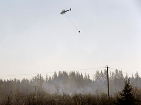 Two helicopters and twenty five firefighters fight a brush fire near Duffield, Alberta, a hamlet located approximately sixty five kilometers west of Edmonton on April 18, 2016.