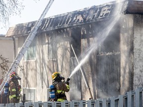 Firefighters battle a blaze inside a four-plex in the Forest Lawn area of Calgary, Alta., on Saturday, April 2, 2016.