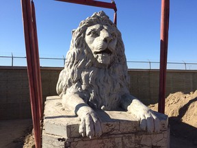 Workers prepare to remove the original Centre Street bridge lions during restoration work in 2000. Three of the four lions have been sitting in a storage lot ever since.