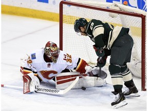 Calgary Flames goalie Niklas Backstrom (32), of Finland, blocks a shot by Minnesota Wild right wing Jason Pominville (29) during the first period of an NHL hockey game Saturday, April 9, 2016, in St. Paul, Minn.