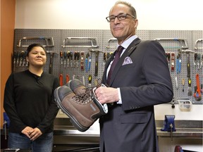 Alberta Finance Minister Joe Ceci prepares to donate work boots to Women Building Futures student Kim Brertton, left, during a pre-budget photo opportunity in Edmonton, on Monday April 13, 2016.