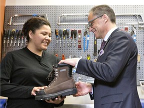 Alberta Finance Minister Joe Ceci donates work boots to Women Building Futures student Kim Brertton during a pre budget photo opportunity in Edmonton on Monday April 13, 2016.