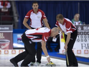 Team Canada third John Morris follows as second Carter Rycroft (right) and lead Nolan Thiessen (left) sweep his rock during round robin competition against Team Newfoundland and Labrador at the Brier curling championship, Wednesday, March 9, 2016 in Ottawa.