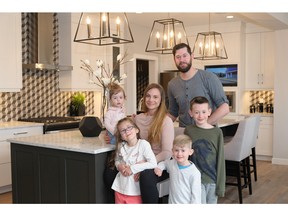 Josh, Katie Capps, with their children Kail, Ava, Zach, and Cora in the kitchen of a show home by Calbridge Homes in Legacy.