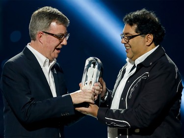 Calgary mayor Naheed Nenshi (R) hands a Juno Award to Jim Watson, mayor of Ottawa, the next host city of the Juno Awards, during the Juno Awards at the Scotiabank Saddledome in Calgary, Alta., on Sunday, April 3, 2016. The Juno Awards celebrate the best in Canadian music. (Lyle Aspinall/Postmedia Network)