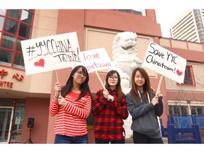 (L-R) Kelly Ma, 17, Maggie Ha, 14, and Alana Eng, 13 yrs, hold signs at the Chinese Cultural Centre on Sunday.