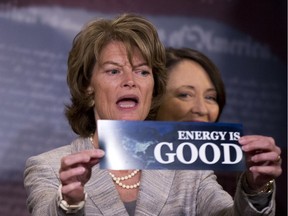 Senate Energy and Natural Resources Committee chair Sen. Lisa Murkowski, R-Alaska, left, accompanied by the committee's ranking member Sen. Maria Cantwell, D-Wash. holds a bumper sticker during a news conference on Capitol Hill in Washington, Wednesday, April 20, 2016. The Senate approved a wide-ranging energy bill Wednesday  that would promote a variety of energy sources and speed U.S. approval of projects to export liquefied natural gas to Europe and Asia.
