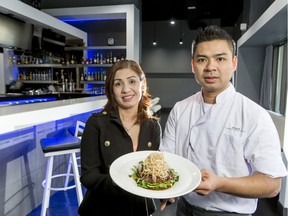 Co-owners and mother/son duo Ngoc Vo (L) and Lam Pham hold a papaya mango salad inside Pure Contemporary Vietnamese in Calgary.