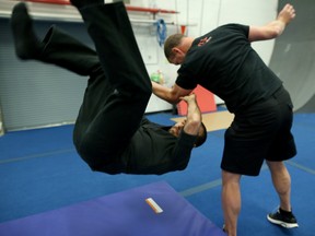 Stunt man and trainer Steven McMichael, right, flips Postmedia reporter Damien Wood during a training exercise at The Flip Factory in Calgary, Alta., on Sunday April 24, 2016.