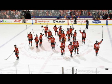 The Calgary Flames raise their sticks after winning against the Vancouver Canucks at the Scotiabank Saddledome in Calgary, AB., on Thursday, April 7, 2016. The Flames won the NHL regular season game 7-3. (Photo by Andy Maxwell Mawji/ Postmedia)