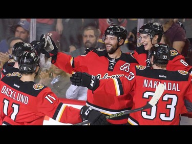 Derek Engelland of the Calgary Flames celebrates with teammates, from the left, Mikael Backlund, Joe Colborne and Jakub Nakladal after scoring on the Vancouver Canucks, a 7-3 win, during the final home game of the year at the Saddledome Thursday night April 7, 2016.  (Ted Rhodes/Postmedia)
