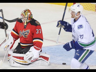 Calgary Flames goalie Joni Ortio sags in hsi crease on the Vancouver Canucks first gooal of  the first period at the Saddledome Thursday night April 7, 2016.  Skating past is Daniel Sedin of the Canucks. (Ted Rhodes/Postmedia)