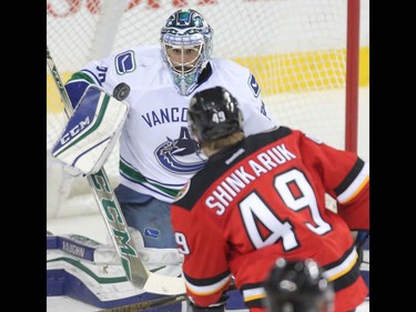 Hunter Shinkaruk of the Calgary Flames fies a shot off the blocker of Vancouver Canucks goalie Ryan Miller in the first period at the Saddledome Thursday night April 7, 2016.  (Ted Rhodes/Postmedia)