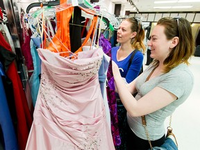 Eliza Richardson (R) and her mom Erica Richardson browse a rack of dresses during the GownTown event at Marlborough Mall in Calgary on Sunday, April 17, 2016. Donated prom dresses were on sale for $10 each for just two hours, with proceeds benefitting Aspen Family. Network