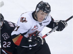 Rebels Brandon Hagel (L) battles Hitment Beck Malenstyn during Western Hockey League playoff action between the Red Deer Rebels and the Calgary Hitmen at the Stampede Corral in Calgary, Alta on Friday April 1, 2016. Jim Wells//Postmedia