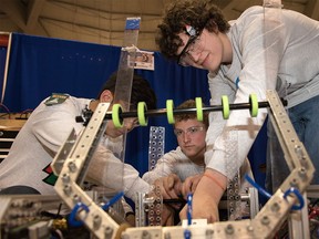 Ethan Cow, Aaron Brokaw and Andy Hobelsberger, members of team Robodawgs, make adjustments to their robot at the Olympic Oval in Calgary, Ab, on Monday, April 4, 2016. FIRST Robotics hosted a regional robotics competition for high school students from Calgary and around the world.