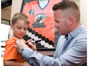 Ryan Montgomery, who plays Tike level lacrosse, gets his shirt autographed by lacrosse player Bob Snider in Calgary, Ab, on Wednesday, April 20, 2016. Snider's jersey is being retired by the Calgary Hornets. Elizabeth Cameron/Postmedia ORG XMIT: Bob Snider