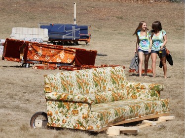 2010: Ashley Stenning (left) and Lane Millar walk through the destroyed couches that were used in a couch race during the annual Bermuda Shorts day.