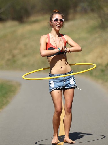 Skye Lawlor enjoys some hula hoop action while walking on the bike path in Stanley Park in Calgary on Tuesday, April 19, 2016. Lawlor was with friends and enjoying the hot temps and cooling off in the river.