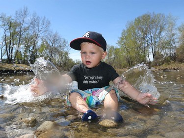Hank Vanonen splashes and keeps cool in the Elbow River in Stanley Park with his mom Ally Kelly in Calgary on Tuesday, April 19, 2016.