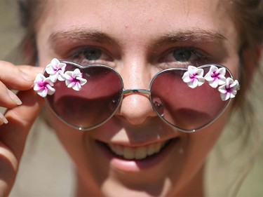Skye Lawlor shows her fancy flowery sunglasses as she enjoys some hula hoop action while walking on the bike path in Stanley Park in Calgary on Tuesday, April 19, 2016. Lawlor was with friends and enjoying the hot temps and cooling off in the river.