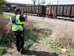 Police deal with a pedestrian collision next to a Canadian Pacific freight train near Horton Road and Southland Drive in Calgary on Wednesday, May 4, 2016.