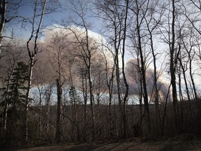 A view of a large orange plume of smoke coming from a rapidly expanding wildfire west of Fort McMurray