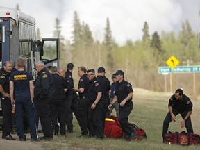 Firefighters from Edmonton arrive on Alberta Highway 63 near Fort McMurray on May 5, 2016. An out-of-control wildfire covering over 10,000 hectares of forest has forced the evacuation of Fort McMurray, the fourth largest city in Alberta. Over 80,000 residents of the northern Alberta city have been evacuated as fire threatens to consume the city and surrounding area. A provincial state of emergency has been declared in Alberta. (PHOTO BY LARRY WONG/POSTMEDIA NETWORK)