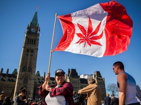 A woman waves a flag with a marijuana leaf on it next to a group gathered to celebrate National Marijuana Day on Parliament Hill in Ottawa, Canada on April 20, 2016.   Canada will take steps next year to legalize marijuana, Health Minister Jane Philpott announced. Philpott offered several reasons for ending the ban on pot, including the view that laws in Canada and abroad criminalizing marijuana use have been both overly-harsh and ineffective. / AFP PHOTO / Chris RoussakisCHRIS ROUSSAKIS/AFP/Getty Images