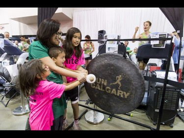 Dave Proctor (R) works on setting his world record as his wife Sharon and kids Adele, Sammy and Julia bang a gong to mark his final 30 minutes during the Calgary Marathon Expo at the Big Four Building in Calgary, Alta., on Saturday, May 28, 2016. Seven world records for treadmill running were broken, including Dave Proctor's 24-hour run, all in support of MitoCanada. Lyle Aspinall/Postmedia Network