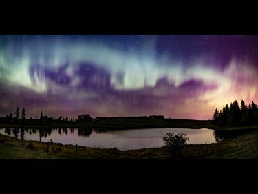 Multi-photo panorama of northern lights reflected in a pond west of Calgary, Ab., on Sunday May 8, 2016. Mike Drew/Postmedia