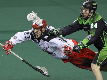 Calgary Roughnecks Tyler Digby decked by Saskatchewan Rush Ryan Dilks in NLL action at the Scotiabank Saddledome in Calgary, Alta. on Saturday, May 14, 2016. The Rush beat the Roughnecks 16-10. Mike Drew/Postmedia