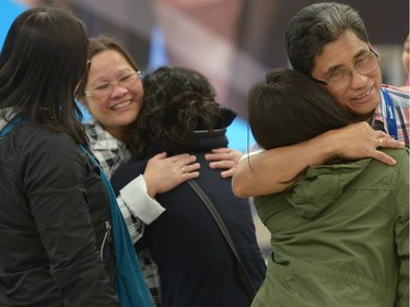 A husband and wife are greeted by her daughters after arriving in Edmonton from the Fort McMurray area on Thursday May 5, 2016. An ever-changing, volatile situation is fraying the nerves of residents and officials alike as a massive wildfire continues to bear down on the Fort McMurray area of northern Alberta.