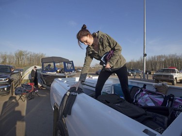 An evacuee gathers clothes from the back of a truck at a rest stop near Fort McMurray on Wednesday, May 4, 2016.