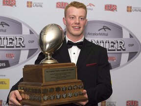 Andrew Buckley, a fifth-year quarterback from the University of Calgary holds the Hec Crighton Trophy as outstanding player in CIS football, during CIS Awards gala, Thursday, November 26, 2015 in Quebec City.