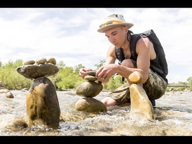 A young man who would only be identified as 'Show Biz' tediously builds cairns, or 'living rocks', in the Bow River at Prince's Island Park in downtown Calgary, Alta., on Wednesday, May 18, 2016. Show Biz says his cairns serve a variety of artistic, therapeutic and calming purposes, his favourite of which is creating a sense of welcomeness and community in an area too often hit with petty crime. Lyle Aspinall/Postmedia Network