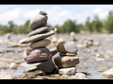 Cairns, or 'living rocks', stand in the Bow River at Prince's Island Park in downtown Calgary, Alta., on Wednesday, May 18, 2016. The young man who made them, who would only identify himself as Show Biz, says his cairns serve a variety of artistic, therapeutic and calming purposes, his favourite of which is creating a sense of welcomeness and community in an area too often hit with petty crime. Lyle Aspinall/Postmedia Network