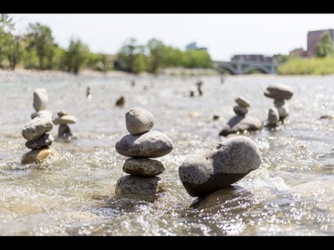 Cairns, or 'living rocks', stand in the Bow River at Prince's Island Park in downtown Calgary, Alta., on Wednesday, May 18, 2016. The young man who made them, who would only identify himself as Show Biz, says his cairns serve a variety of artistic, therapeutic and calming purposes, his favourite of which is creating a sense of welcomeness and community in an area too often hit with petty crime. Lyle Aspinall/Postmedia Network