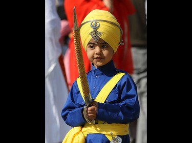 A young Calgarian takes part in the Nagar Kirtan parade in Martindale on Saturday, May 14, 2016. The Nagar Kirtan is a Sikh tradition in which the procession sings hymns and hands out food as they walk through the community.