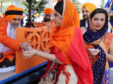 Calgarians are given food from a float during the Nagar Kirtan parade in Martindale on Saturday, May 14, 2016. The Nagar Kirtan is a Sikh tradition in which the procession sings hymns and hands out food as they walk through the community.