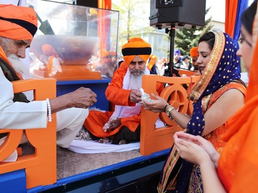 Calgarians are given food from a float during the Nagar Kirtan parade in Martindale on Saturday, May 14, 2016. The Nagar Kirtan is a Sikh tradition in which the procession sings hymns and hands out food as they walk through the community.