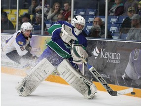 Calgary Canucks goaltender Logan Drackett shoots the puck out from behind the net with Fort McMurray Oil Barons forward Isaac Ceh chasing after him during AJHL action at the Casman Centre in Fort McMurray Alta. on Saturday October 10, 2015. Drackett made 45 saves Saturday as the the Canucks defeated the MOB by a 3-0 score. Robert Murray/Fort McMurray Today/Postmedia Network