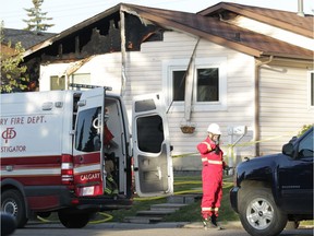 Calgary firefighters and police investigate at the scene of a fire in Falconridge where five people died in Calgary, on Saturday May 7, 2016. The house in this image is next door to the house where heavy damage occurred.Jim Wells//Postmedia