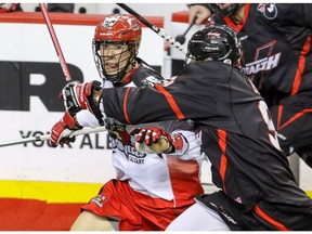 Calgary Roughnecks Karsen Leung is grabbed by Vancouver Stealth Keegan Bal in NLL action at the Scotiabank Saddledome in Calgary, Alta. on Saturday January 30, 2016. Mike Drew/Postmedia